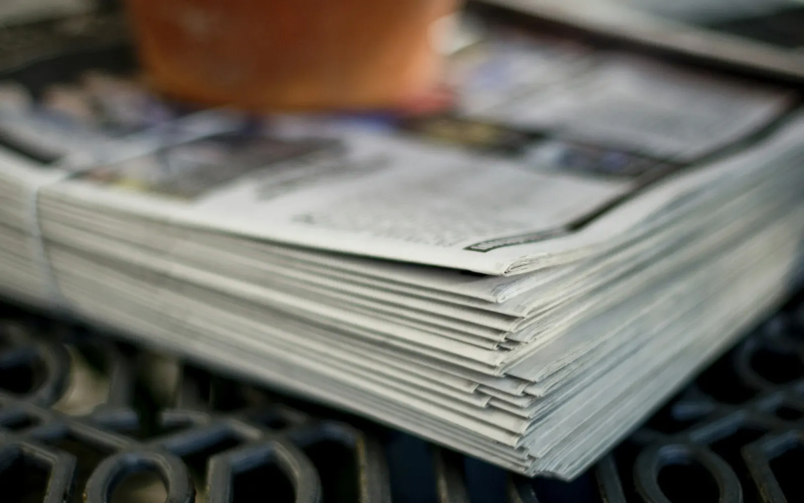 Illustrative photo: a stack of folded newspapers. Not a sample of the Press Release (UK News Style) deliverable.